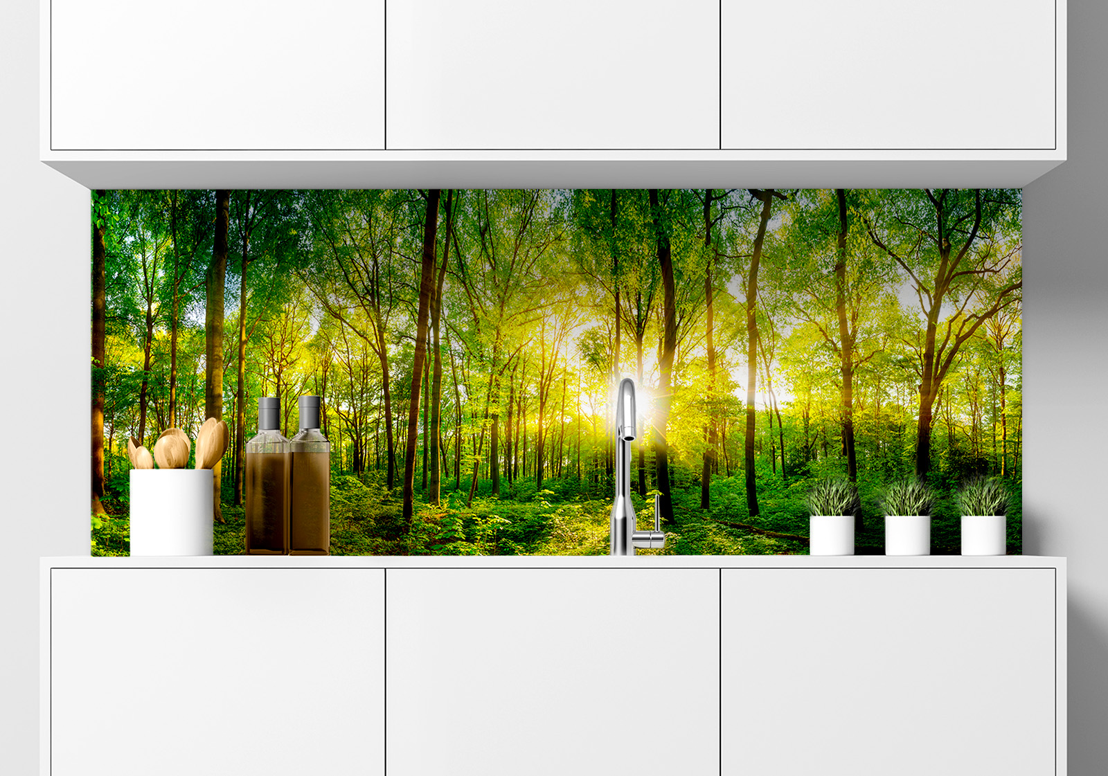 Küchenrückwand -  sonnendurchfluteter Wald Küche mit weißen Hängeschränken, Spüle mit Armatur, Gewürzständer und kleinen Topfpflanzen auf der Arbeitsfläche. Es ist eine Küchenrückwand mit folgendem Motiv verbaut: Sonnenstrahlen durchdringen dichten grünen Wald mit hohen Bäumen, Panoramaansicht.