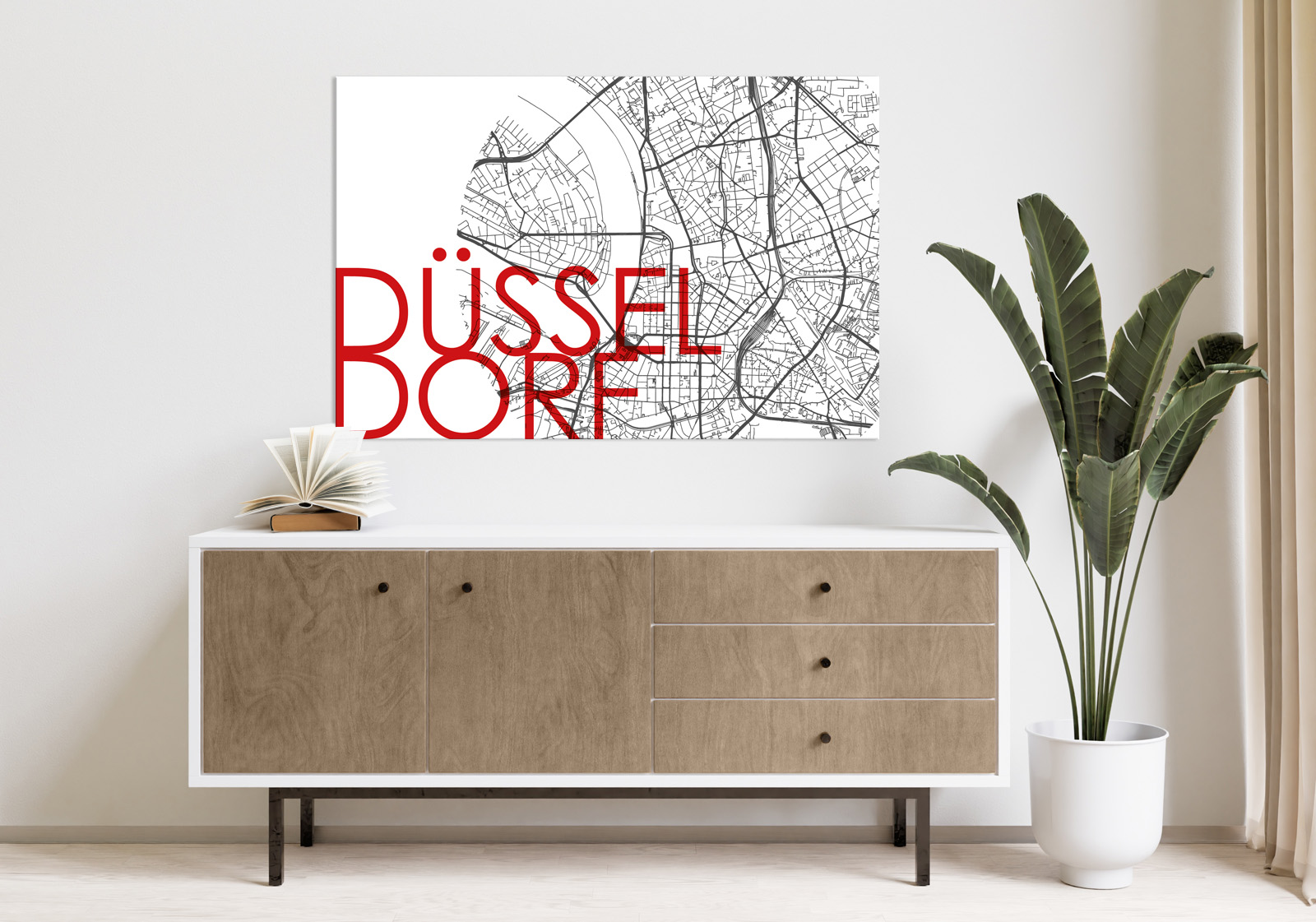 Milieubild mit hellem Holzsideboard mit Pflanze und darüber ein Wandbild mit folgendem Motiv: Ausschnitt einer schwarz-weißen Stadtkarte von Düsseldorf in einem Kreis, mit dem roten Wort "DÜSSELDORF" auf der linken Seite.