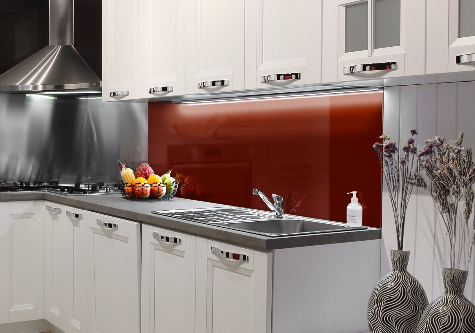 RW-K-P_Unifarben-05.jpg Weiße Küche mit Edelstahl-Dunstabzugshaube, Spüle, Obstschale und zwei Vasen mit Dekozweigen. Es ist eine Küchenrückwand mit folgendem Motiv verbaut: Einfarbig dunkelrotes Bild, keine sichtbaren Details oder Muster.
