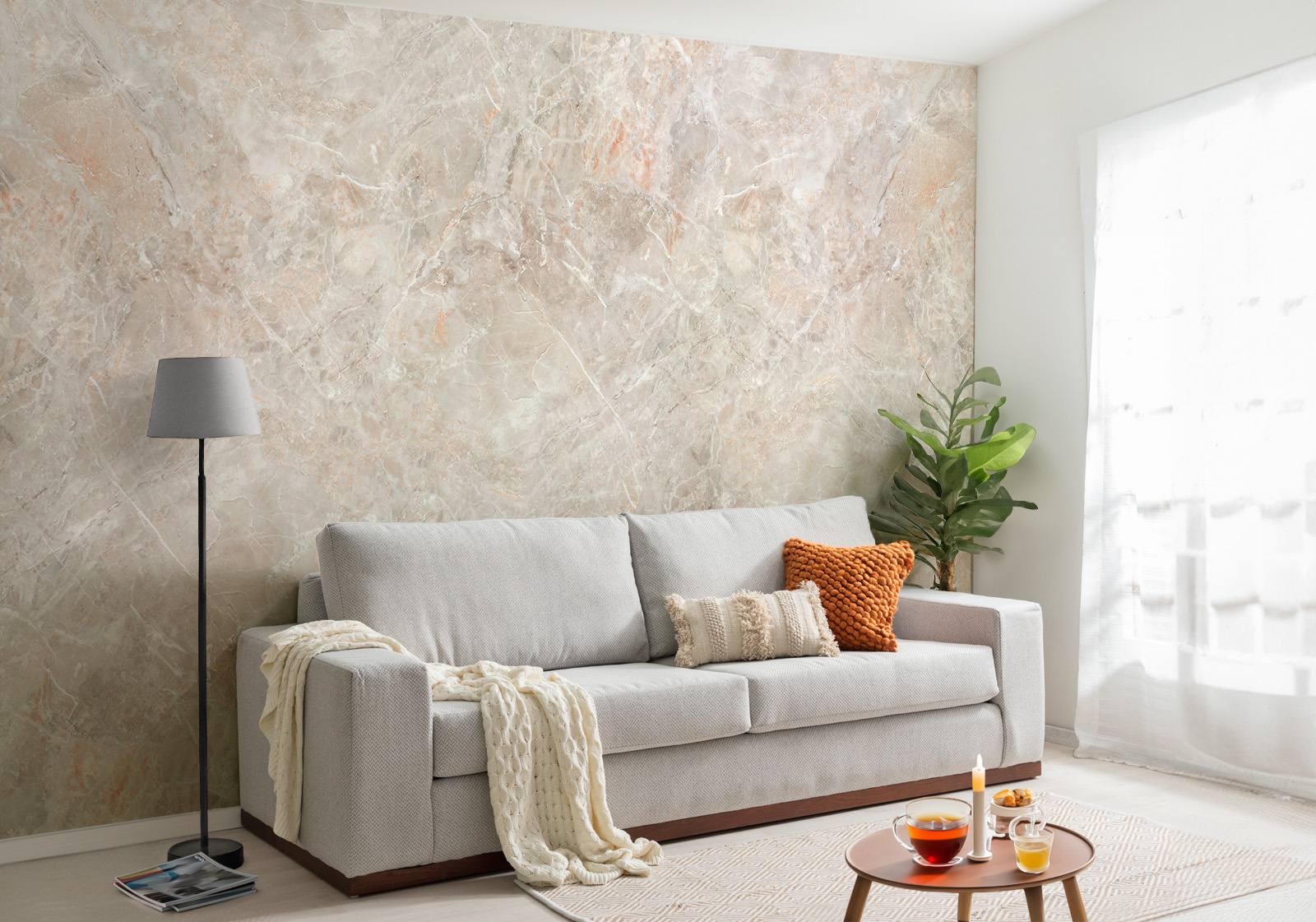 Milieubild mit Wohnzimmer mit grauer Couch, Zierkissen, Decke, Beistelltisch, Lampe, Pflanze und einer Wandverkleidung mit folgendem Motiv: Beiger Marmor mit grauen und orangefarbenen Adern, abstrakte Textur.