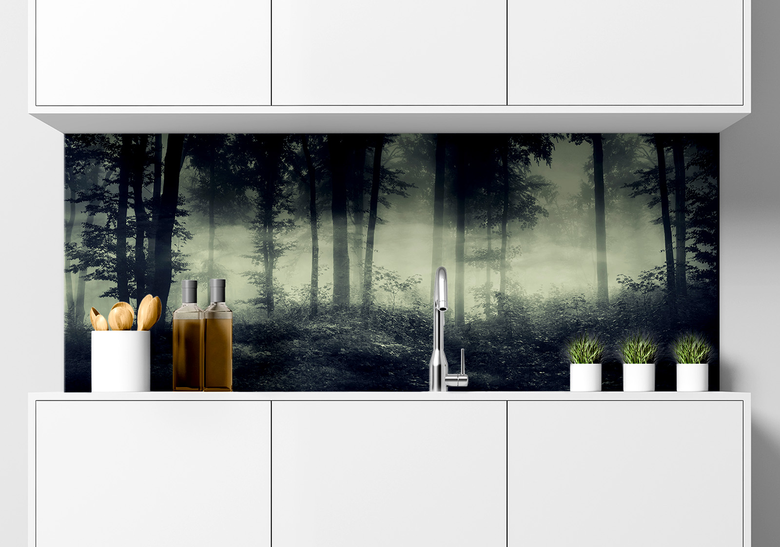 Küche mit weißen Hängeschränken, Spüle mit Armatur, Gewürzständer und kleinen Topfpflanzen auf der Arbeitsfläche. Es ist eine Küchenrückwand mit folgendem Motiv verbaut: Dunkler Wald mit Nebel, hohe Bäume und Unterholz, mystische Atmosphäre.