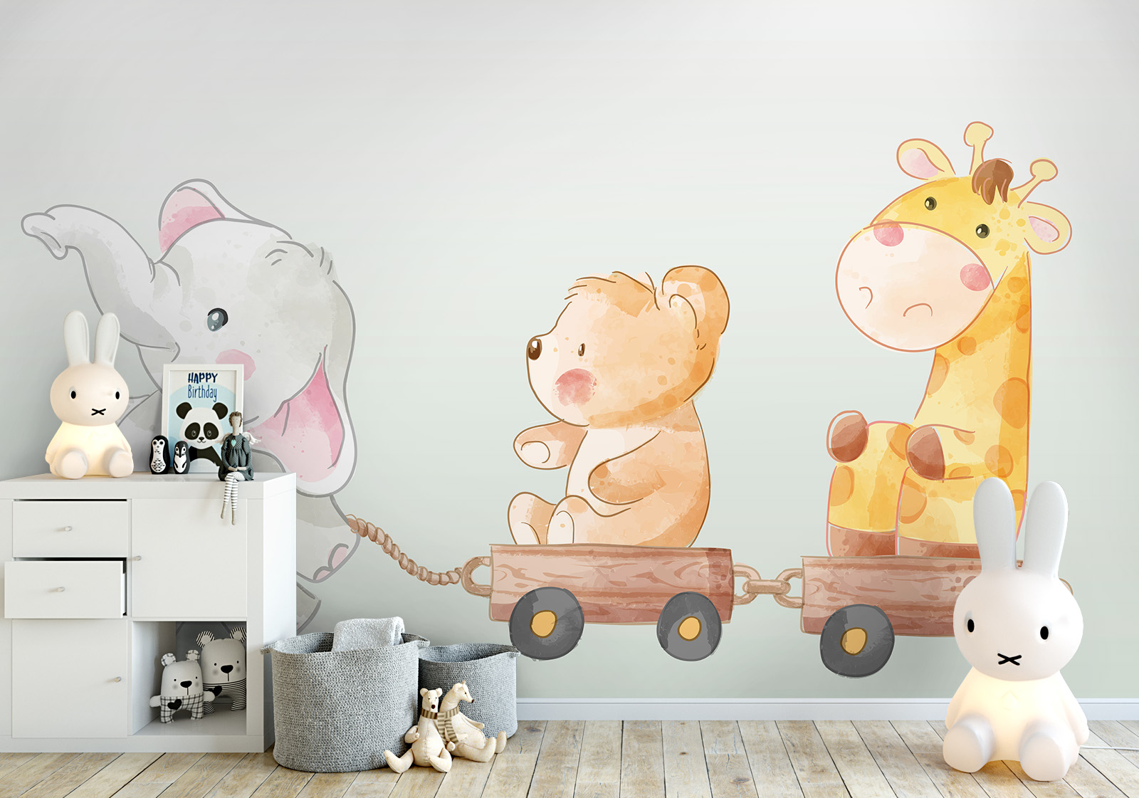 Wandverkleidung für das Kinderzimmer - Freunde auf Tour Milieubild mit  Kinderzimmer, weißer Kommode, Hasenlampe, Spielzeug, grauen Körben und  Wandverkleidung mit Motiv: Illustration eines Elefanten, Bären und einer Giraffe als Spielzeugtiere, die auf einem Zug mit Holzwaggons fahren.