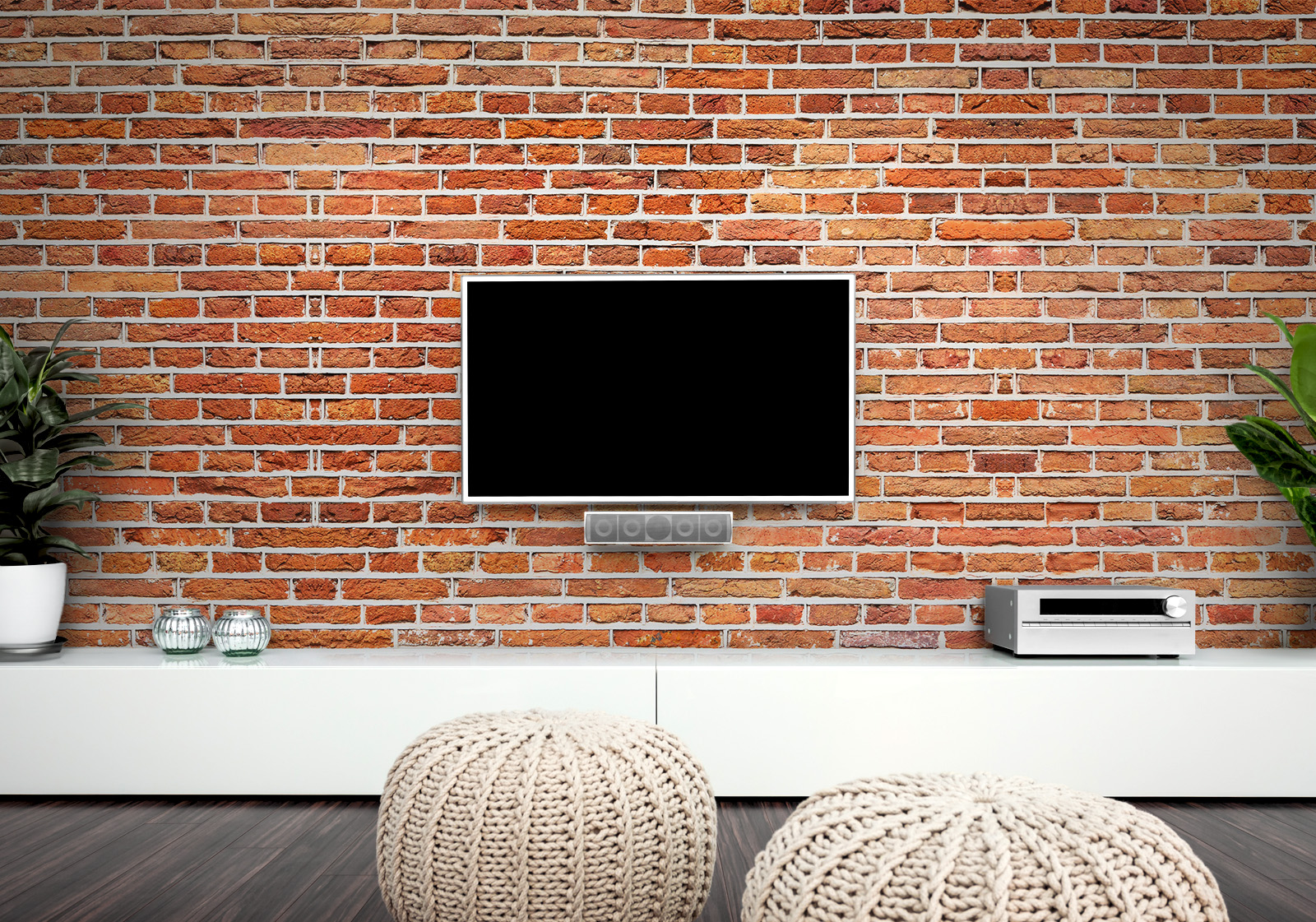 Milieubild mit Wohnzimmer mit TV,  weißer Kommode, grauen Sitzkissen, Zimmerpflanzen und einer Wandverkleidung mit folgendem Motiv: Rote Backsteinmauer mit grauen Fugen, regelmäßiges Muster, Textur.