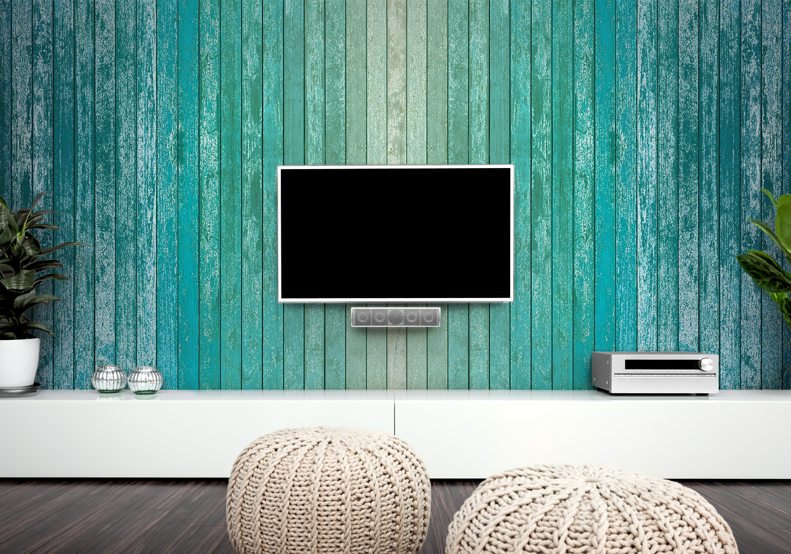 Milieubild mit Wohnzimmer mit TV,  weißer Kommode, grauen Sitzkissen, Zimmerpflanzen und einer Wandverkleidung mit folgendem Motiv: Holzplanken in Farbverlauf von Beige über Türkis bis Dunkelblau, mit sichtbarer Maserung und leichtem Vintage-Effekt.